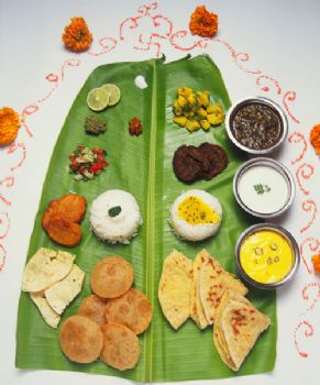 Food served on a banana leaf showing prescribed location of each item.